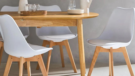 Chaises scandinaves blanches avec pieds en bois autour d’une table design