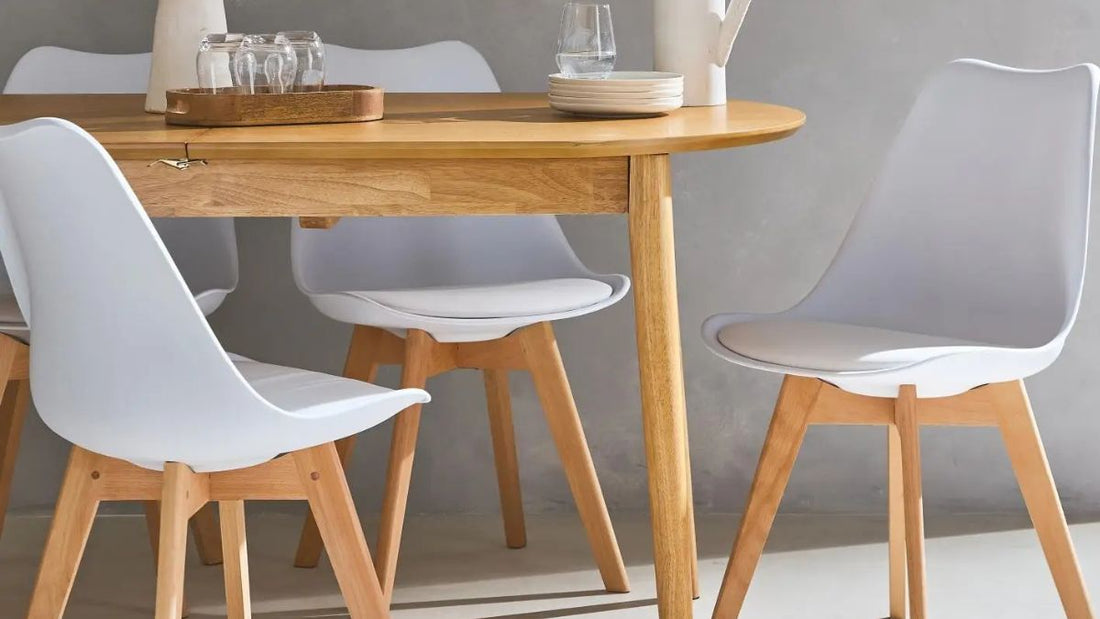 Chaises scandinaves blanches avec pieds en bois autour d’une table design